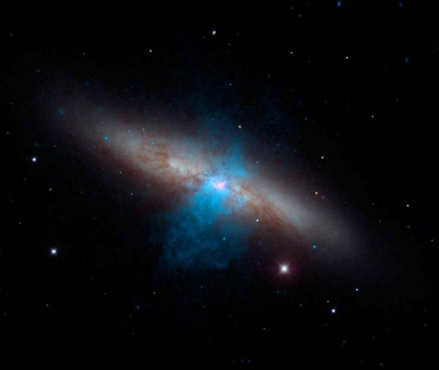 A pulsar (pink) can be seen at the center of the galaxy M82